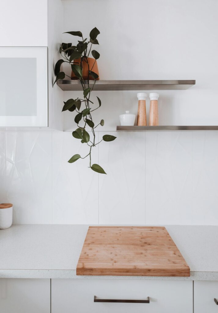 Elegant minimalist kitchen with wooden elements and indoor plant decor.